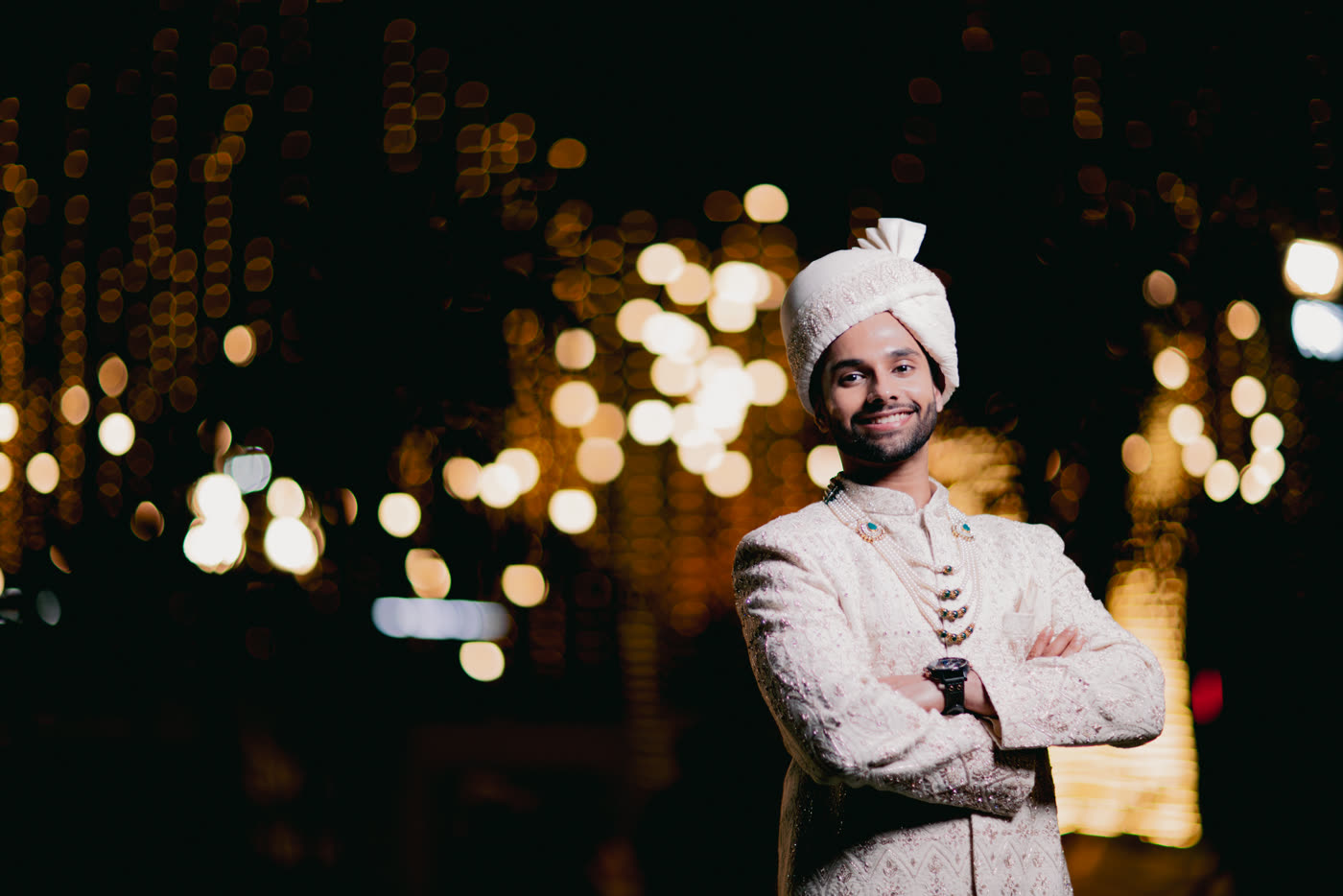 A groom under strings of light